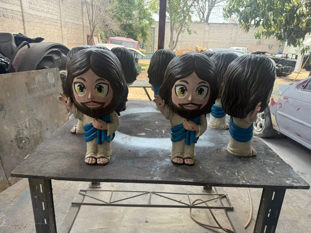 Varias figuras Little Yisus secando en una mesa del taller